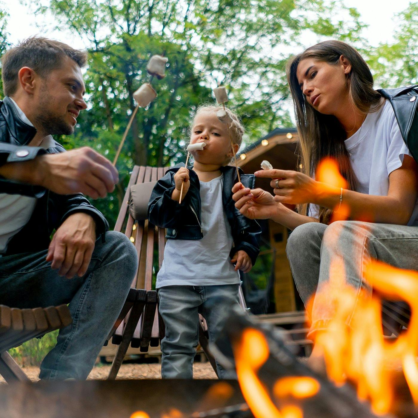 A family roasting marshmallows around a bonfire